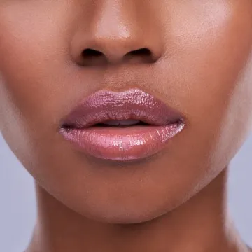 Cropped shot of a young woman's mouth against a purple background